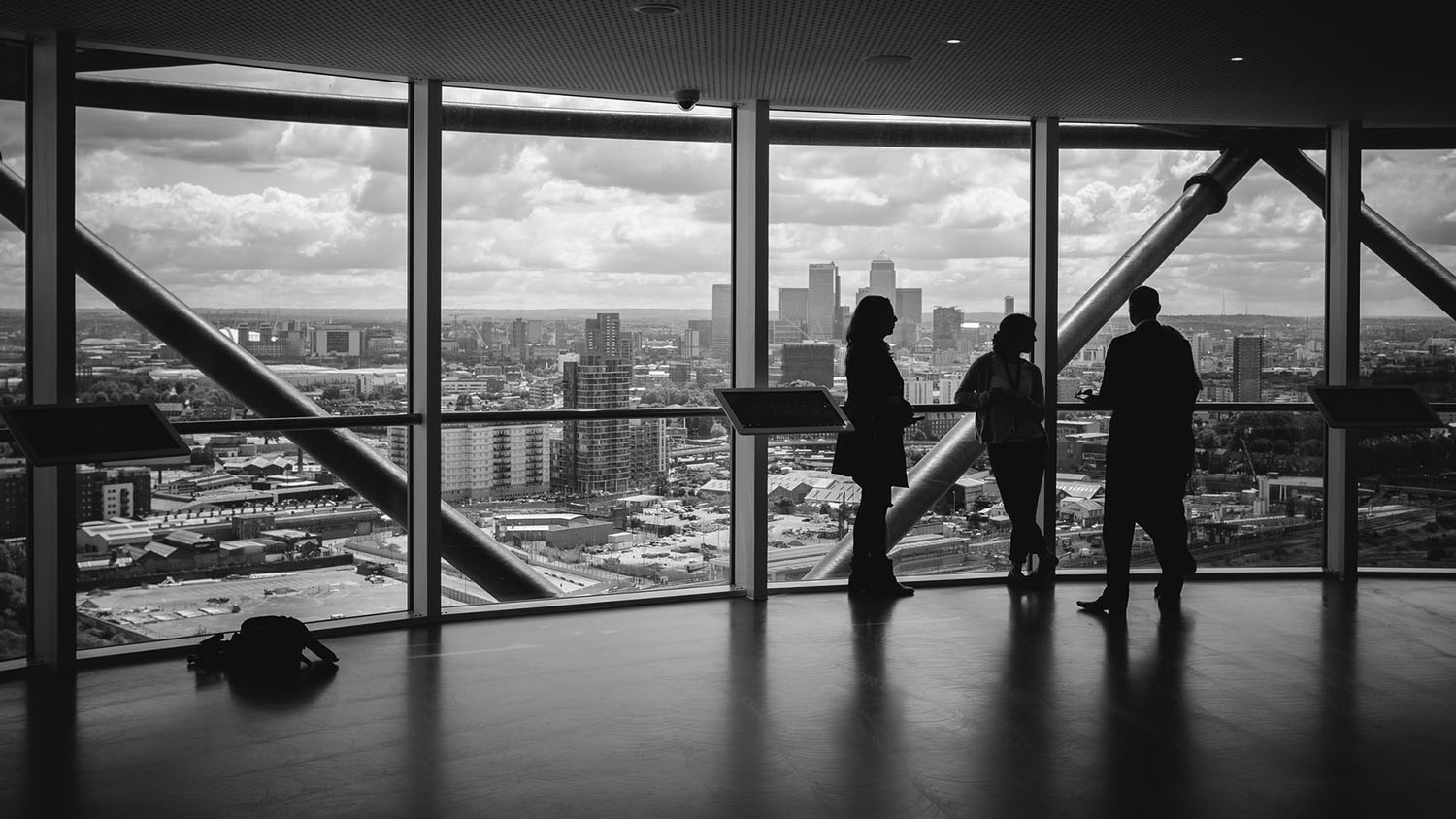 several people in business attire stand in silhouette before a view of a city skyline